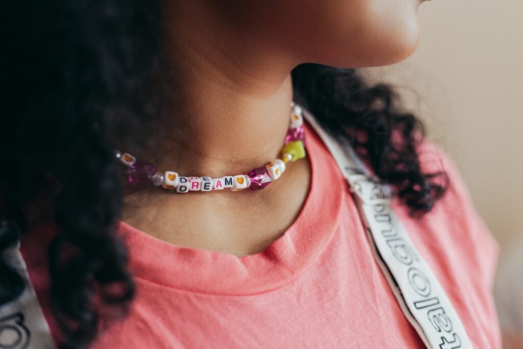 Girl Wearing Pink Shirt and Necklace